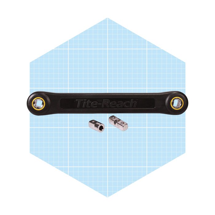 A black wrench with two interchangeable sockets rests in front of a light blue grid background, designed for easy access in tight spaces.