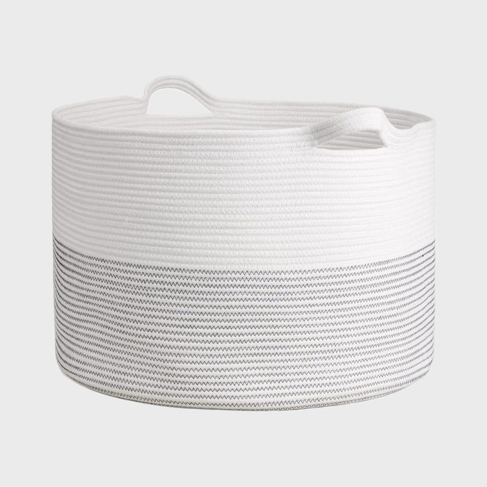A round storage basket with a textured white top section and a patterned gray bottom, designed for organizing items in a home environment.