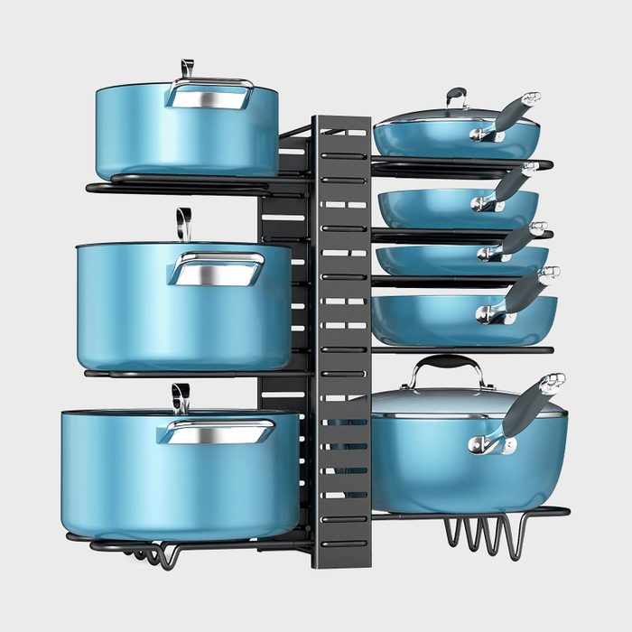 Blue pots and pans are neatly arranged on a black rack, showcasing various sizes and lids in a structured kitchen storage setting.