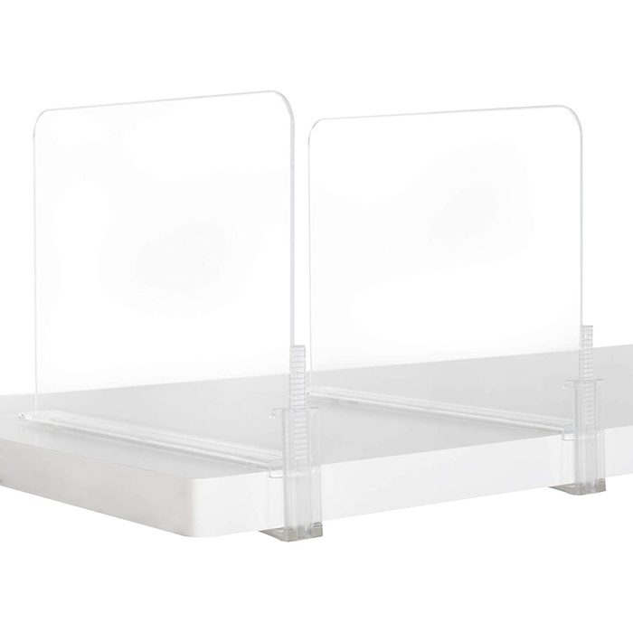 Transparent bookends support books upright on a flat surface, allowing for organized display in a clean, modern setting.