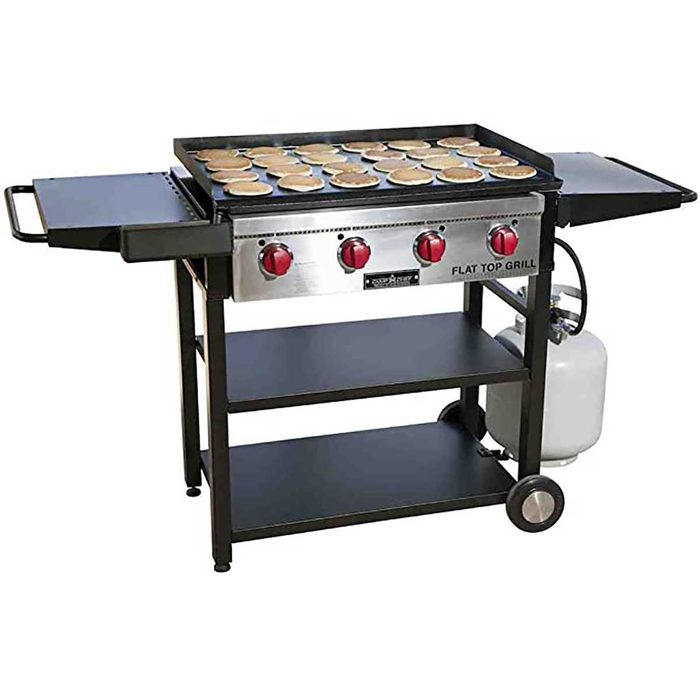 A flat top grill, heated and cooking numerous food items, placed on a wheeled cart with shelves, suitable for outdoor cooking and gatherings.