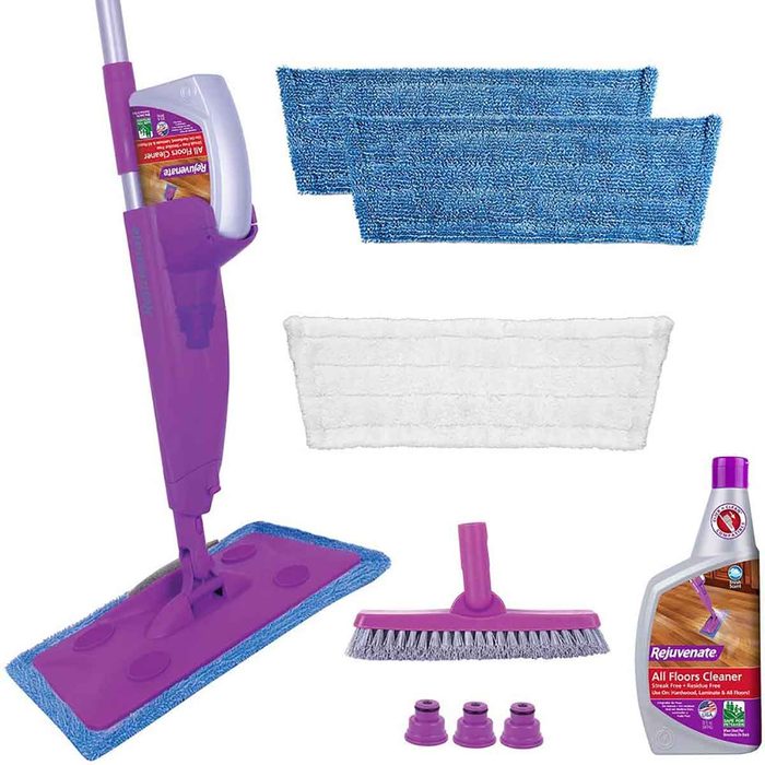 A purple mop with cleaning pads, a bottle of floor cleaner, and accessories are arranged neatly, ready for use in maintaining clean surfaces.