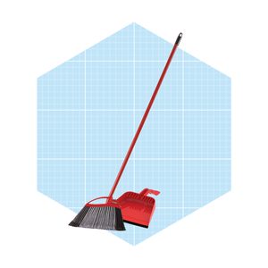 A red broom leans against a red dustpan on a light blue, grid-patterned background, suggesting cleaning activity in a tidy space.