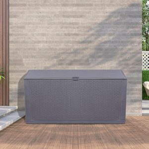 A large, gray storage box sits on a wooden patio floor, against a textured gray wall, with a plant nearby and a glimpse of greenery beyond.