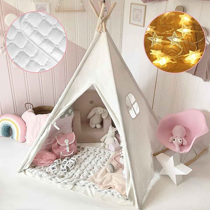 A beige teepee tent houses plush toys and decorative items on a soft blanket, surrounded by pastel decor and soft lighting, creating a cozy play area.