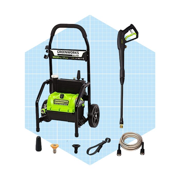 A green and black electric pressure washer stands upright with a spray gun attached. Various nozzles and accessories surround it on a light blue grid background.