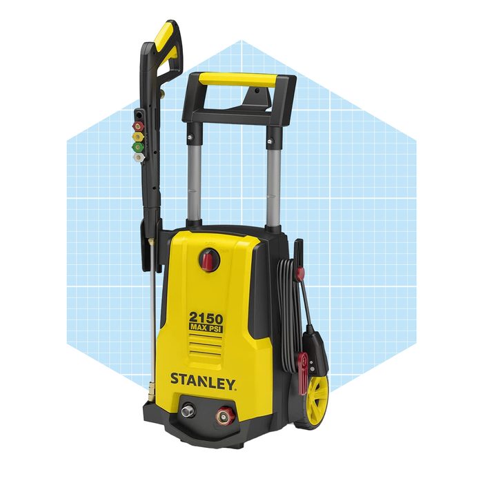A yellow and black pressure washer stands upright, with a handle and spray wand attached, set against a light blue grid background.
