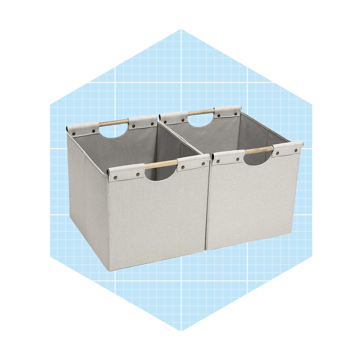 Two fabric storage bins sit side by side, showcasing their open tops and wooden handles, against a light blue grid background.