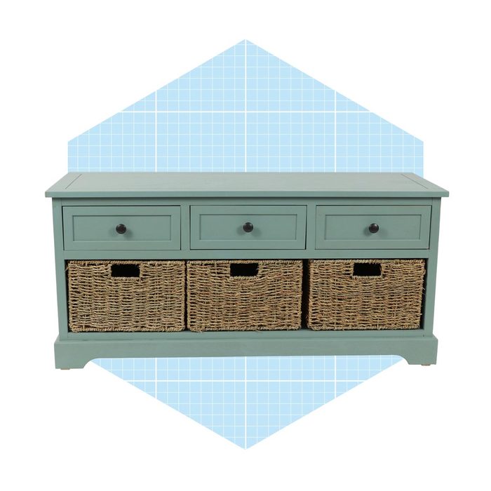 A green wooden cabinet with three drawers and woven baskets below stands against a light blue grid-patterned background.