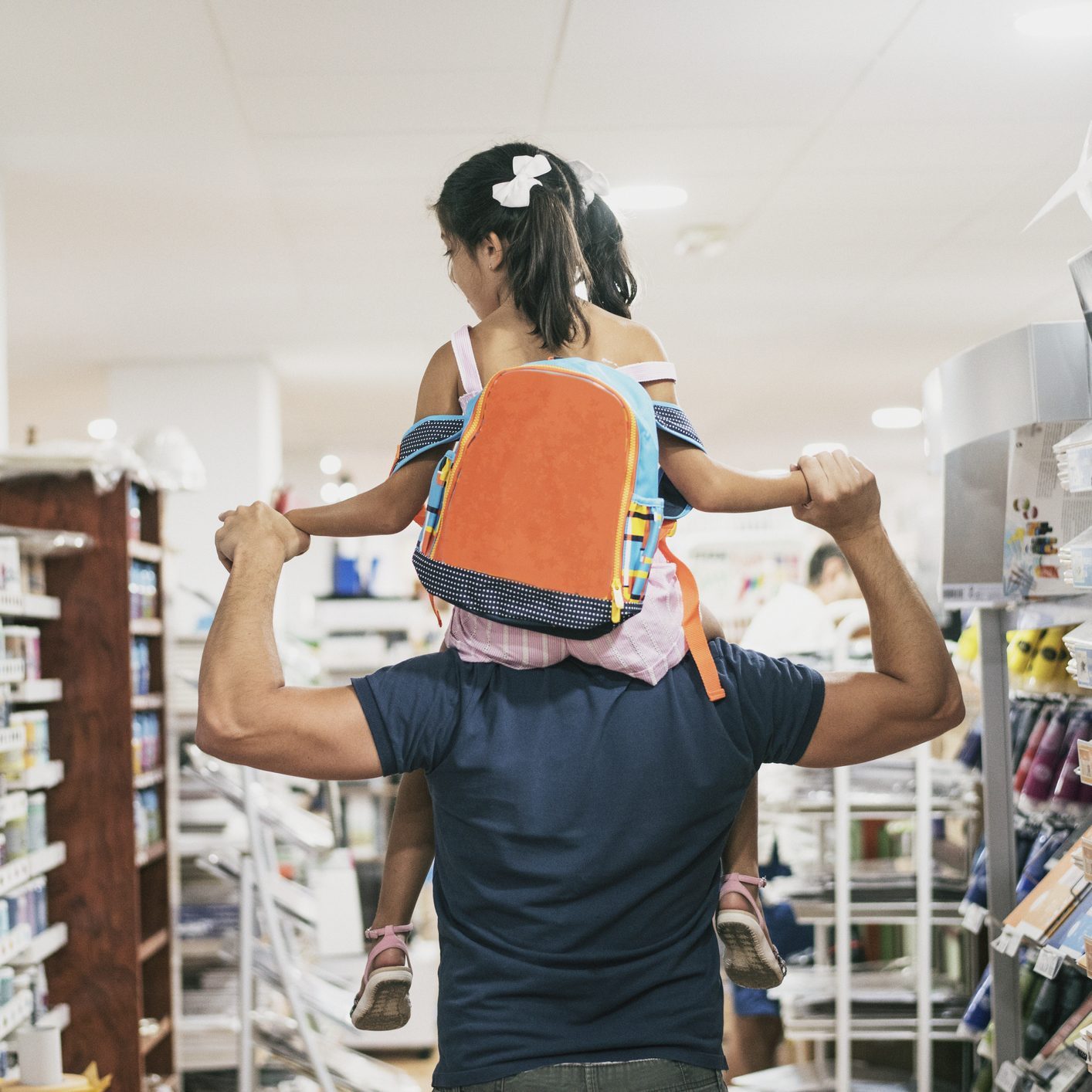 Father and daughter buying school supplies preparing to go back to school, on shoulders
