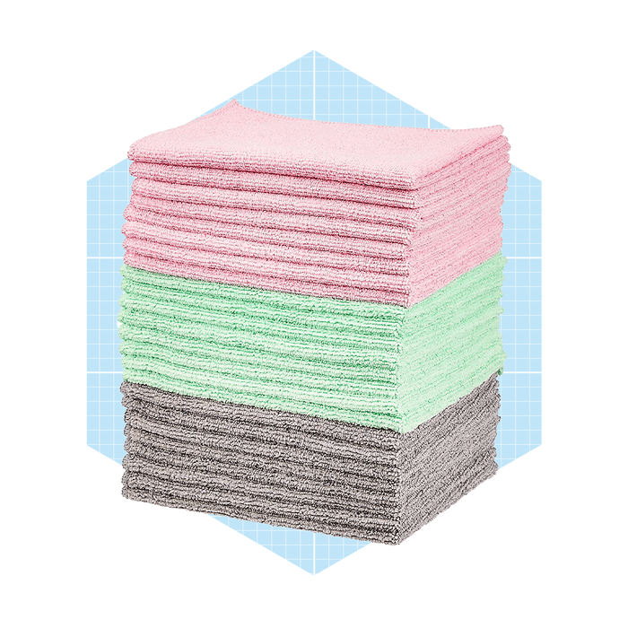 A stack of cleaning cloths in pink, green, and gray, arranged neatly on a light blue geometric background.