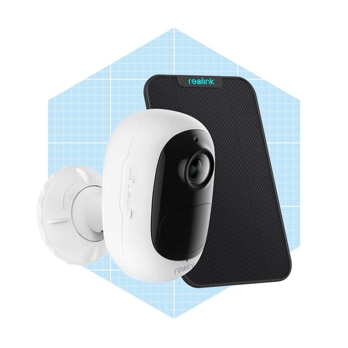 A white security camera mounts on a wall, capturing images, with a black panel in the background, set against a light blue grid pattern.