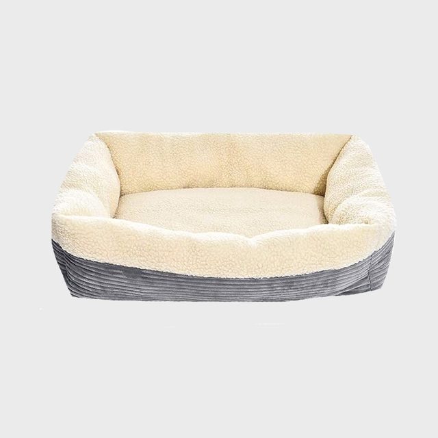 A plush pet bed with a soft cream interior and gray corduroy sides rests on a neutral background, designed for animal comfort and relaxation.