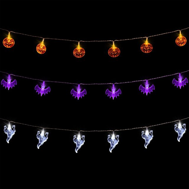 Colorful Halloween-themed string lights featuring orange pumpkins, purple bats, and white ghosts illuminate against a black background, creating a festive atmosphere.