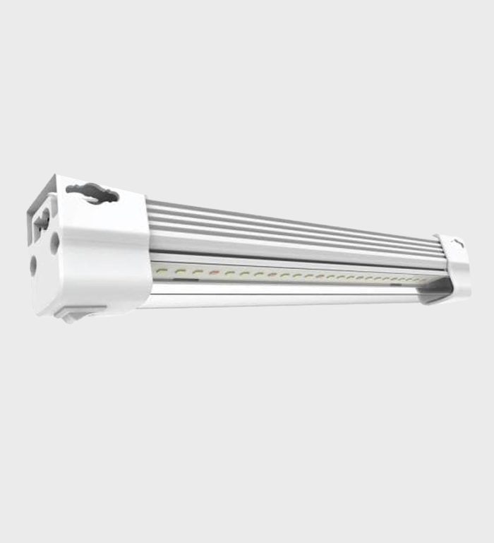A white LED light fixture is mounted horizontally, illuminating a space with bright light. Its sleek design features a ribbed body for heat dissipation.