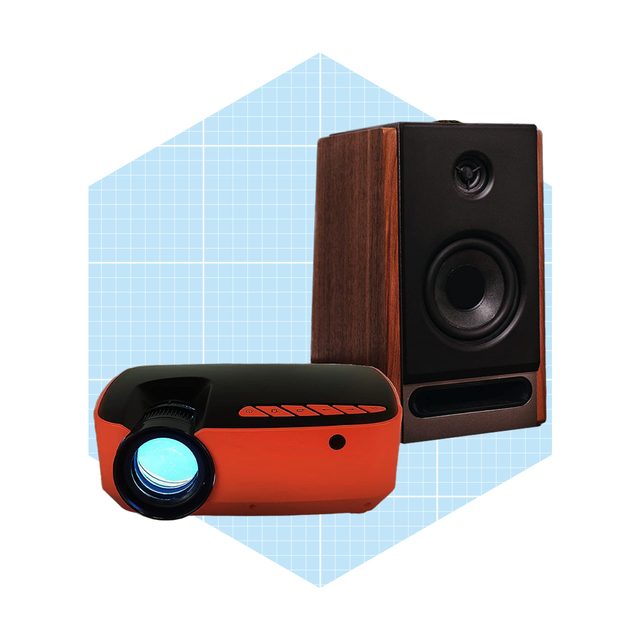 A compact orange projector emits light, placed alongside a wooden speaker. They are set against a light blue, grid-patterned background.