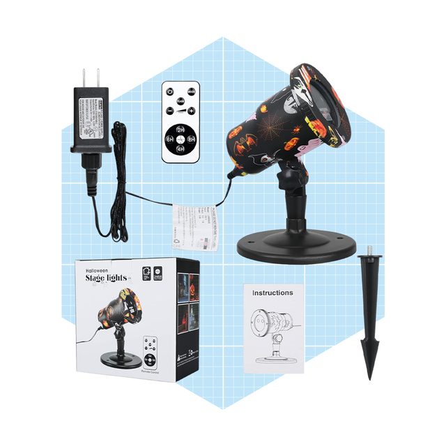 A decorative stage light is positioned with a remote control, power adapter, and instructions, set against a blue grid background for Halloween-themed illumination.