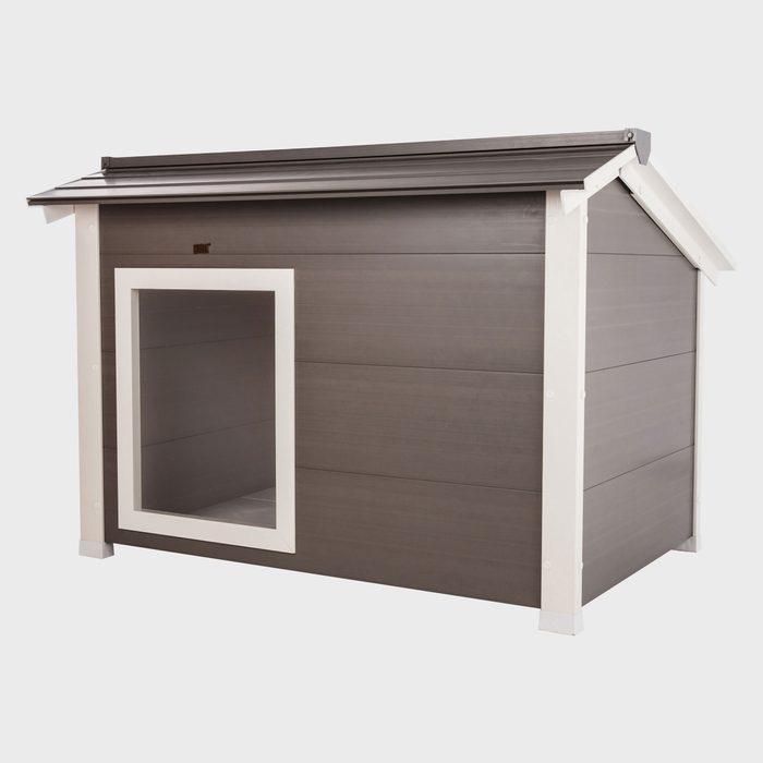 A pet house stands in a neutral background. It has a slanted roof and a square entrance framed in white, offering shelter.