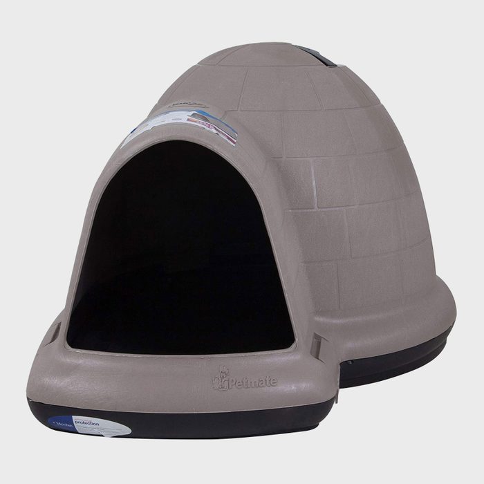 A gray igloo-shaped dog house sits with an open entrance, designed for outdoor pet sheltering. Its textured surface resembles bricks, offering durability and protection.