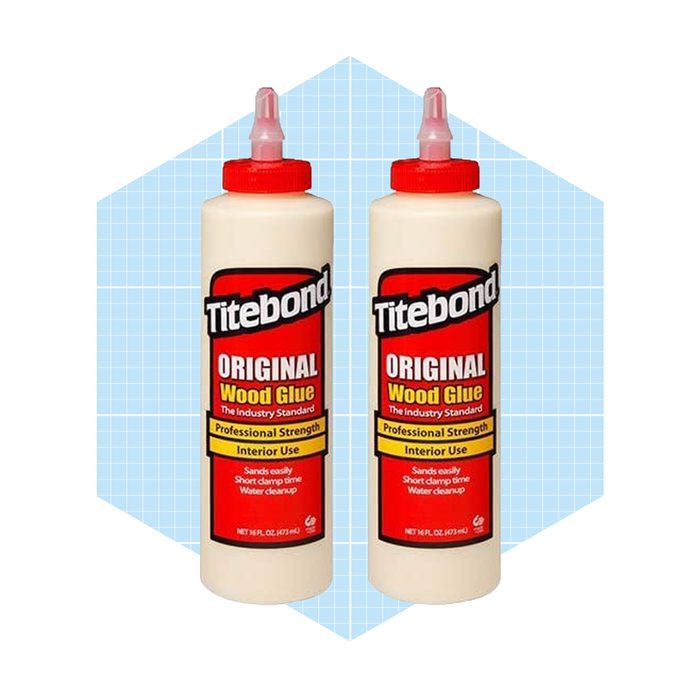 Two bottles of Titebond Original Wood Glue stand upright, showcasing labels that highlight its professional strength for interior use against a light blue grid background.
