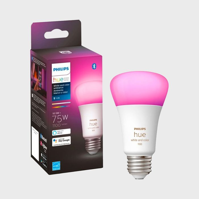 A smart LED light bulb emits a pink glow, displayed beside its packaging, which details features like Bluetooth connectivity and compatibility with voice assistants.