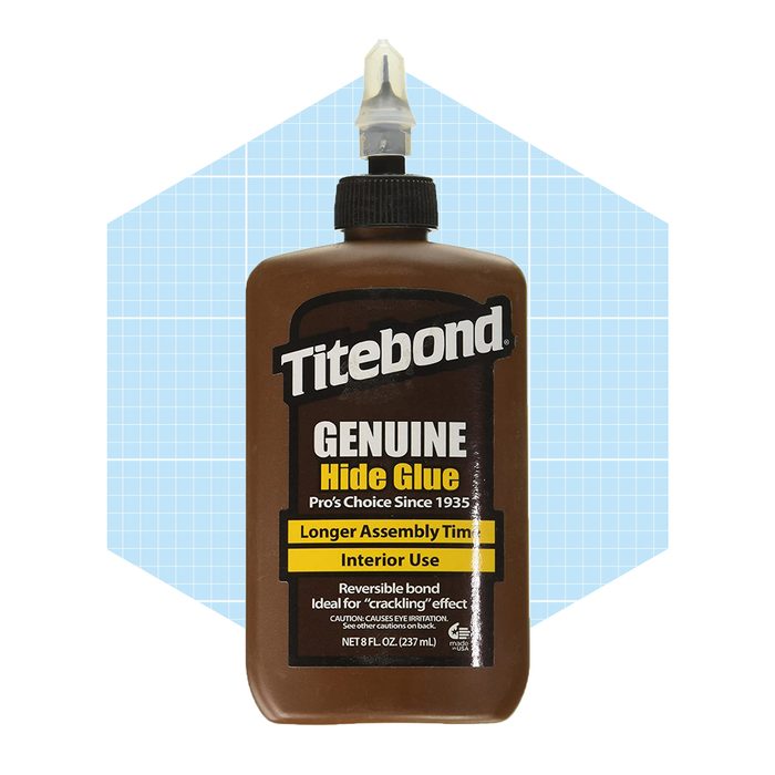 A brown bottle of Titebond Genuine Hide Glue is displayed, featuring a nozzle for application. The background is light blue with a grid pattern.