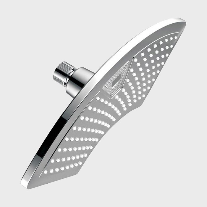 A sleek, modern showerhead sprays water, mounted at an angle. The design features numerous small holes, set against a shiny, reflective surface.
