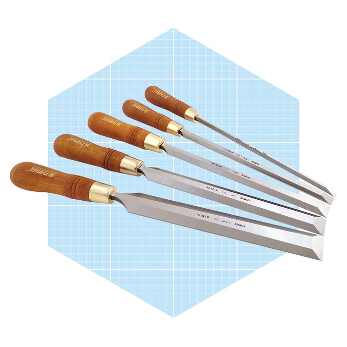 Five chisels with wooden handles are aligned from largest to smallest against a light blue grid background, showcasing their sharp, angled blades.