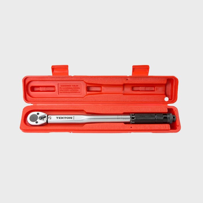 A silver torque wrench rests inside a red hard case, illustrating a tool designed for applying a specific torque to fasteners.