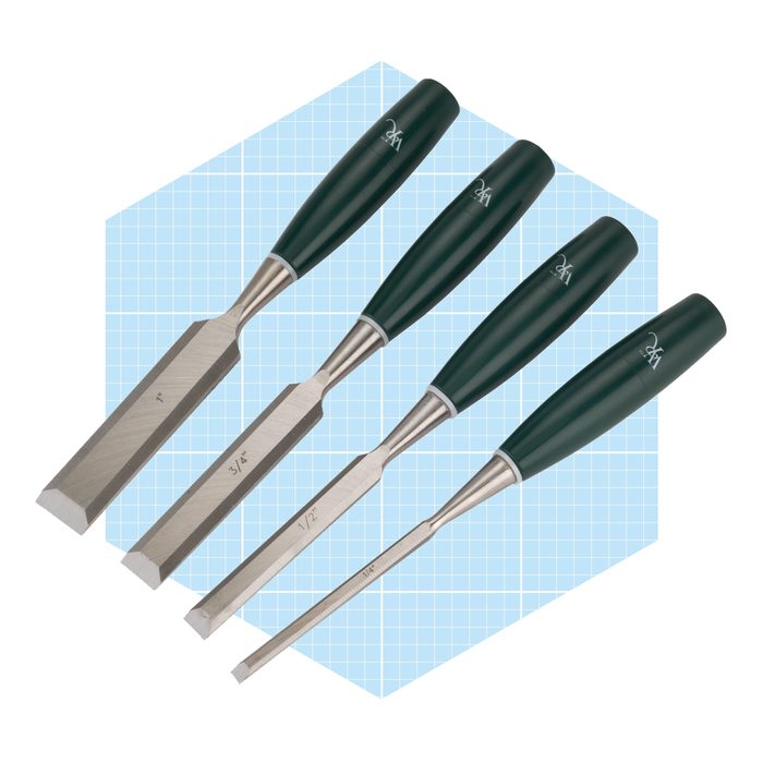 Four chisels with green handles lie on a light blue, grid-patterned background, showcasing a variety of blade widths for woodworking tasks.