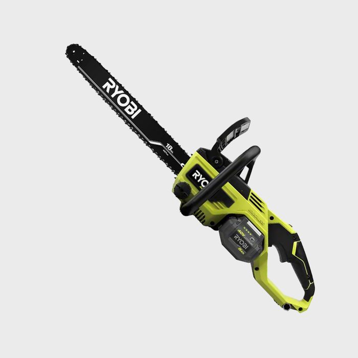 A chainsaw with a green and black design cuts through wood, featuring a long bar and a battery compartment, displayed against a neutral background.