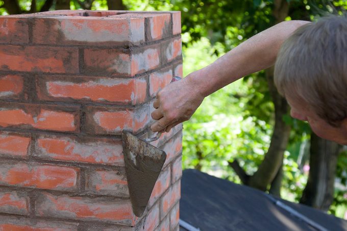 A,man,making,masonry,works,,working,with,a,trowel,and