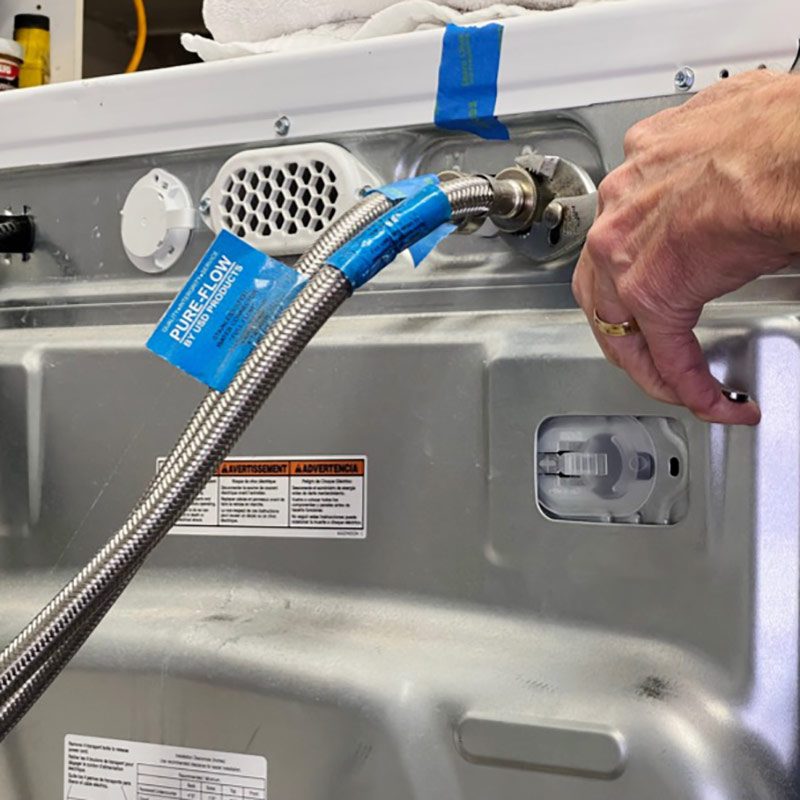 Unscrew water hoses from back of washer