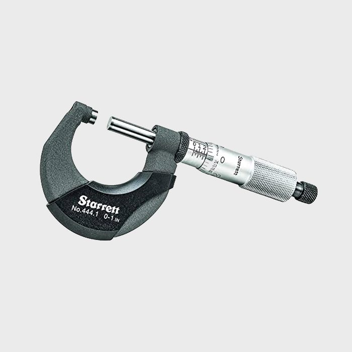 A micrometer gauge measures small distances, featuring a curved metal frame and a calibrated screw mechanism for precise readings, typically used in engineering or manufacturing contexts.