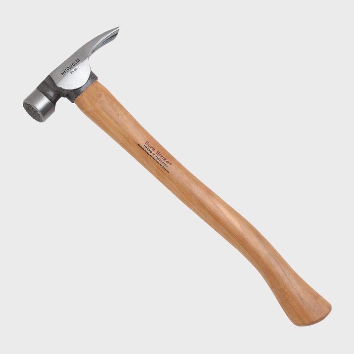 A metal hammer with a wooden handle rests horizontally. It is designed for driving nails. The background is plain and neutral, emphasizing the tool.
