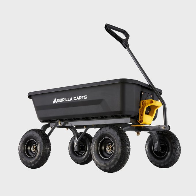 A sturdy, black cart on four durable wheels is positioned upright. It features a handle for pulling, ideal for transporting goods in various environments.