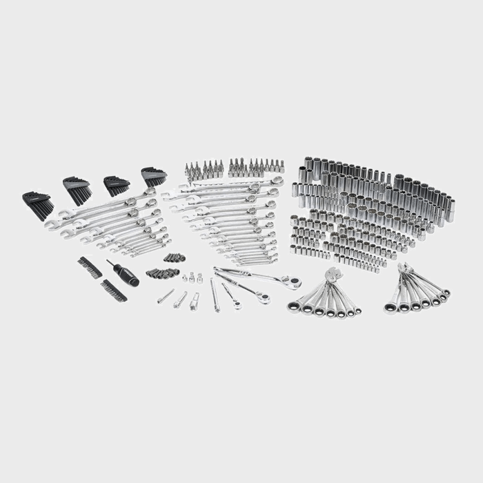 A collection of various metallic tools, including wrenches and sockets, is neatly arranged on a flat surface, showcasing their organized layout for easy access.