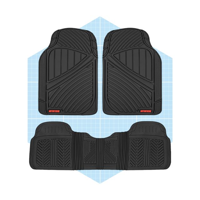 Four black rubber floor mats are arranged symmetrically on a light blue grid background, designed for vehicle use with textured patterns for grip.