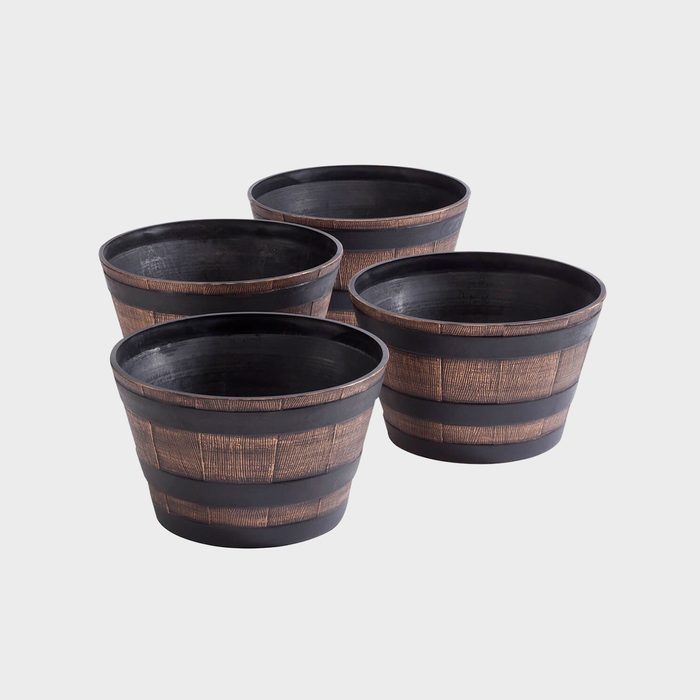 Four wooden-style planters are arranged closely, showcasing their textured surfaces and dark rims against a plain, light background.