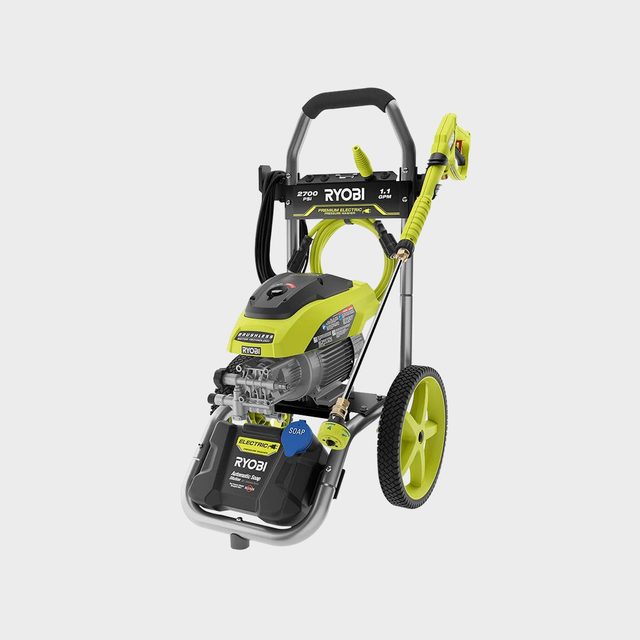 A green and black electric pressure washer stands upright on wheels, featuring a nozzle and a detergent compartment, designed for cleaning surfaces efficiently.