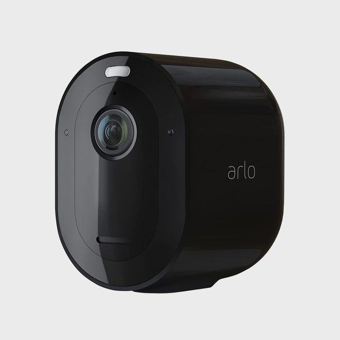 A black security camera is positioned at an angle, featuring a lens and an indicator light on its front, set against a neutral background.