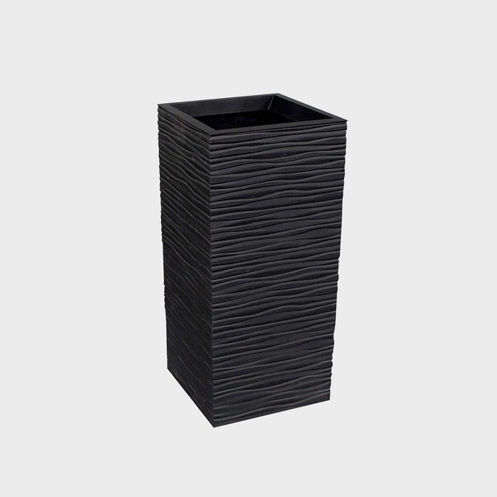 A black, textured rectangular planter stands upright, designed for holding plants, set against a neutral gray background.