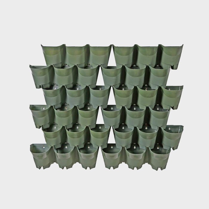 A grid of green wall planters is arranged, showcasing individual pockets for plants, mounted against a neutral, light background.