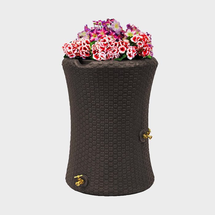A woven, dark brown planter holds vibrant flowers, showcasing colors like pink and purple, in a simple, smooth, and modern design.