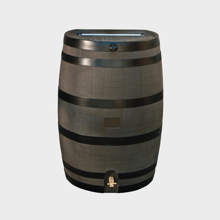 A wooden barrel stands upright, featuring metal bands. It has a top opening and a spout at the bottom, suggesting it collects and dispenses liquid.