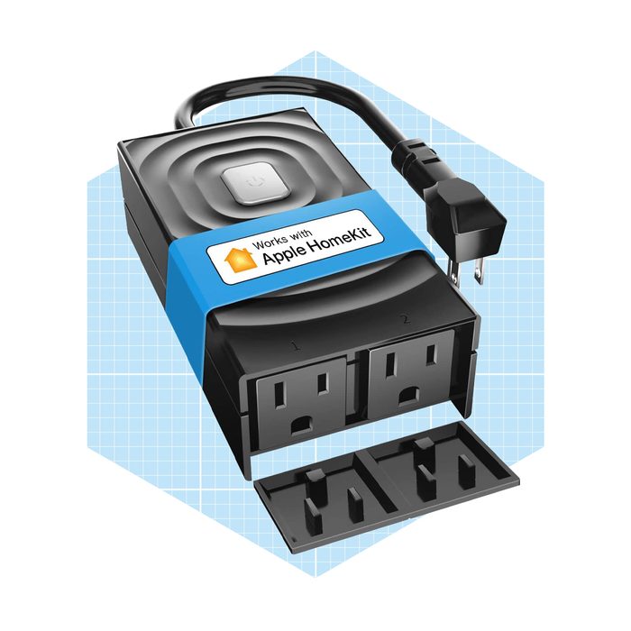 A smart power outlet is plugged in, featuring two outlets and a control button, set against a light blue grid background, labeled for Apple HomeKit compatibility.