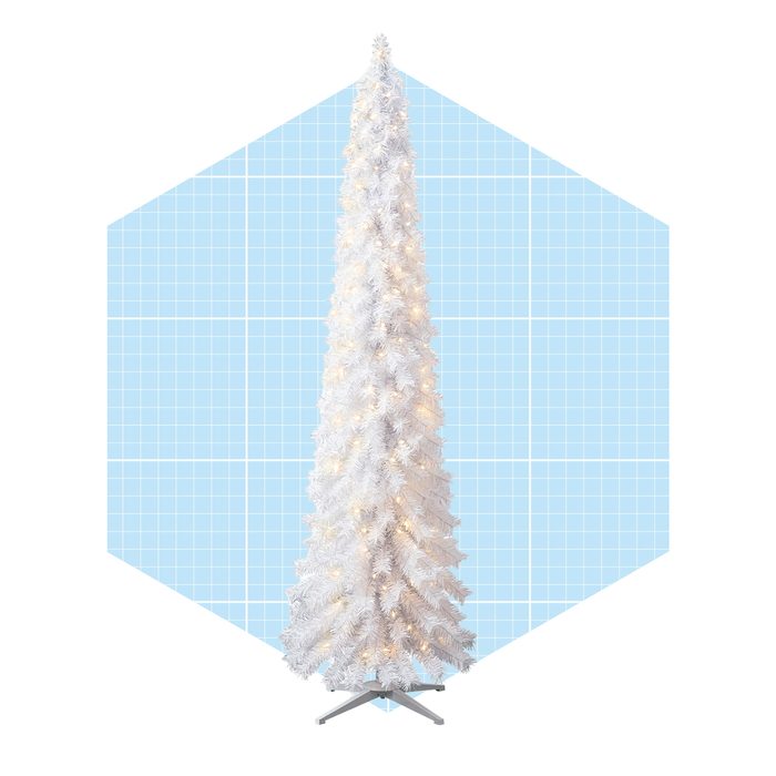 A white Christmas tree stands upright, decorated with lights, against a light blue hexagonal background with a grid pattern, creating a festive holiday ambiance.