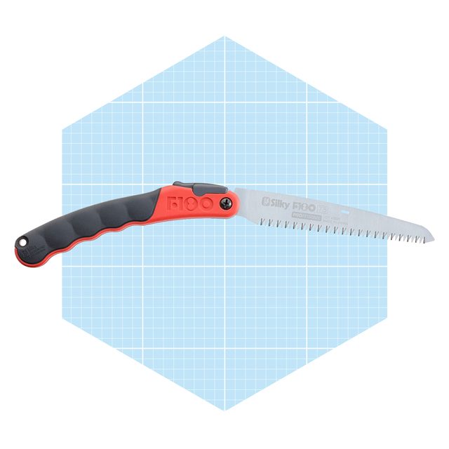 A folding handsaw with a black and red handle is displayed against a light blue grid background. The blade features sharp, serrated edges for cutting.