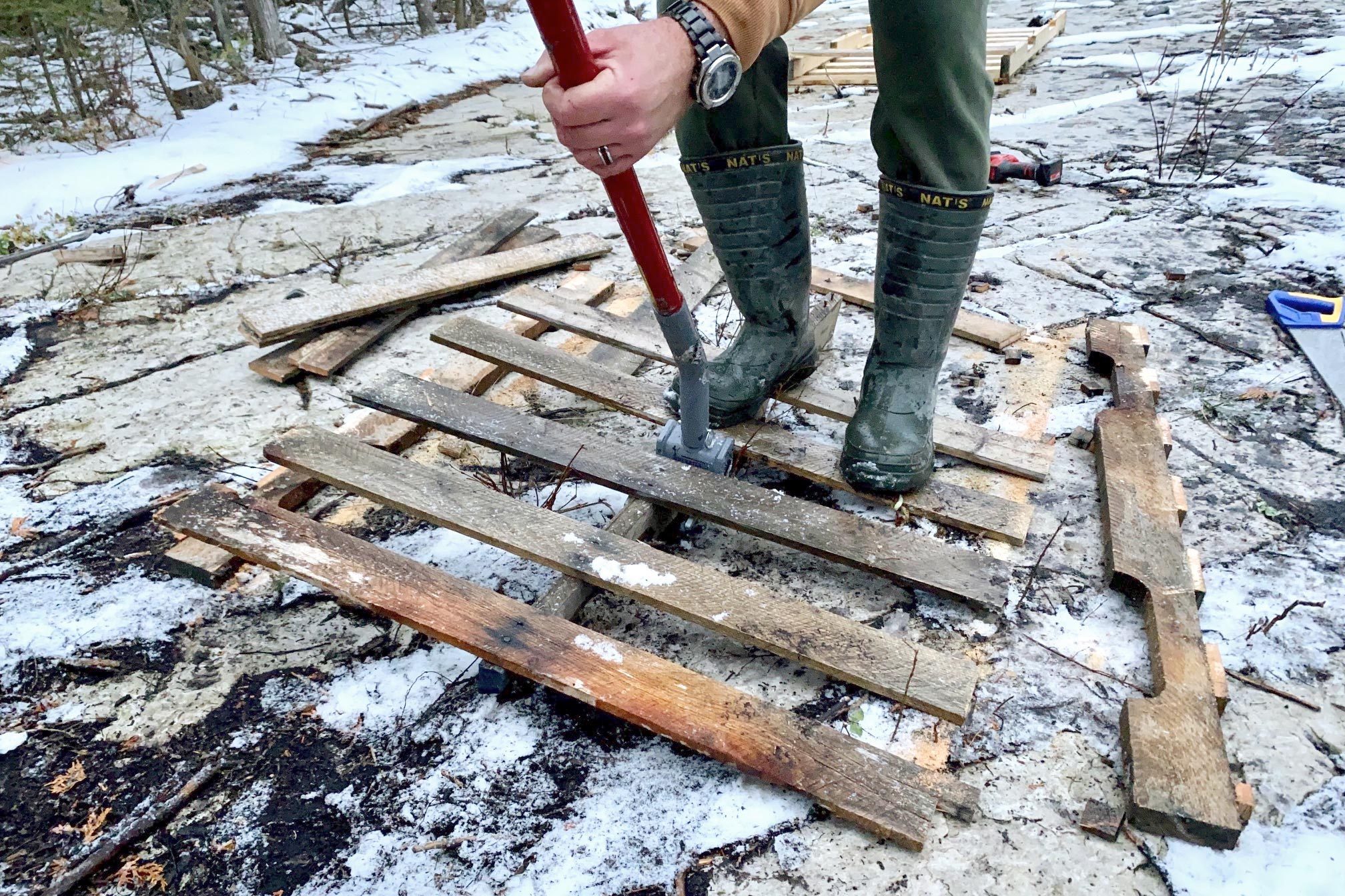 breaking apart a pallet outside