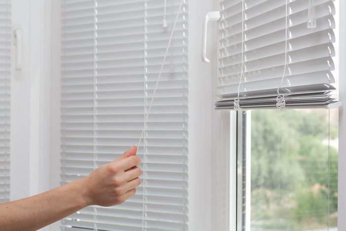 Girls Hand Raise The White Blinds With A Cord